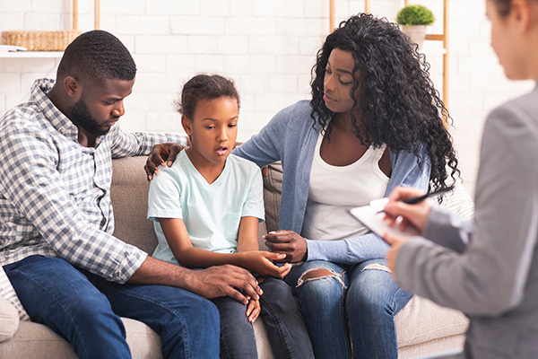 A family consisting of two adults and one child in a family counseling session